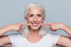 woman pointing to dentures