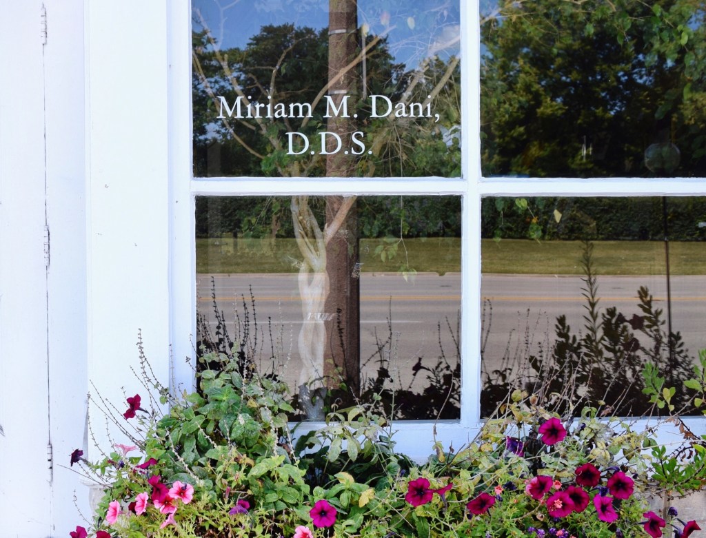 A close-up view of a clinic window reflecting the outdoors, with 