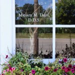A close-up view of a clinic window reflecting the outdoors, with 