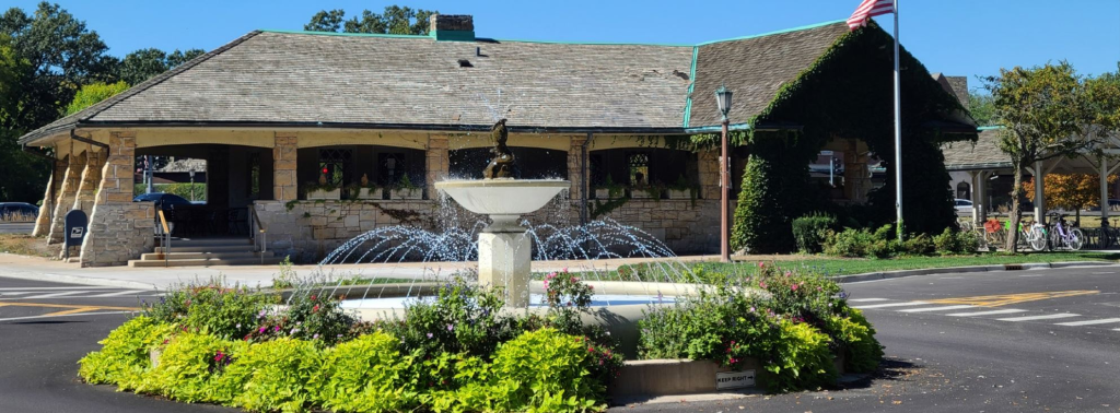 Wide shot of the dental office building featuring a manicured garden and a small decorative fountain in the foreground