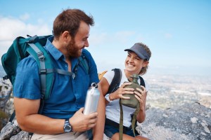 Young couple on a hike laughing together.